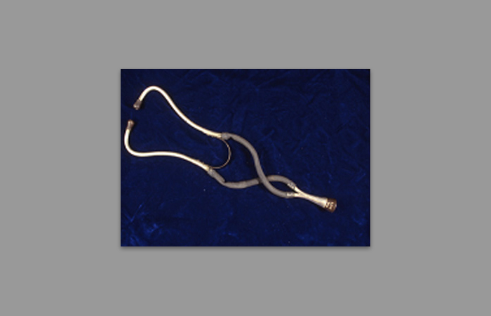 Binaural stethoscope with metal ear tubes and rubber tubing.