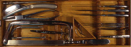 Wood case with fabric lining, filled with metal autopsy instruments