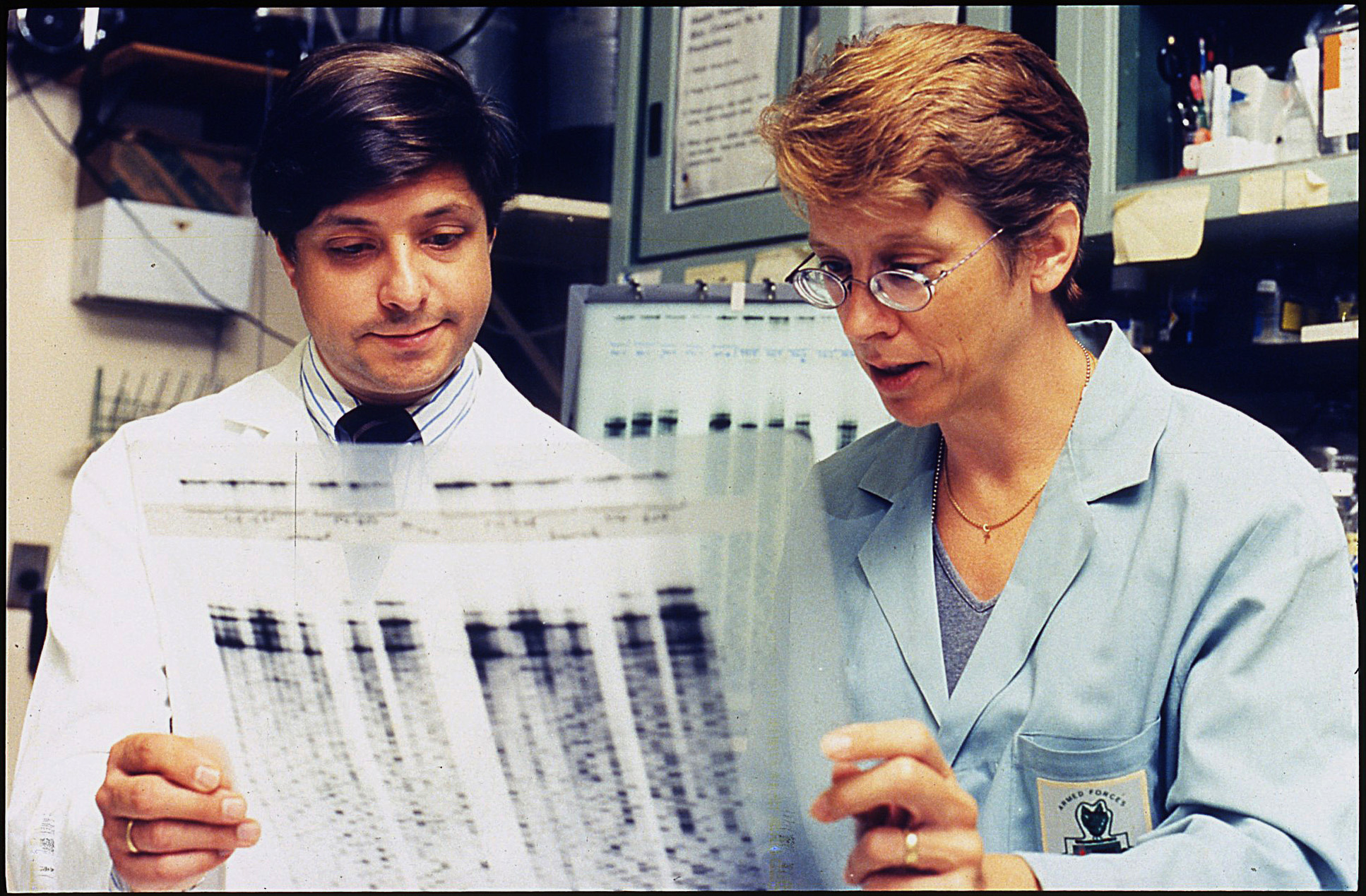 Taubenberger and Ann Reid hold up genetic sequencing transparency in their laboratory.